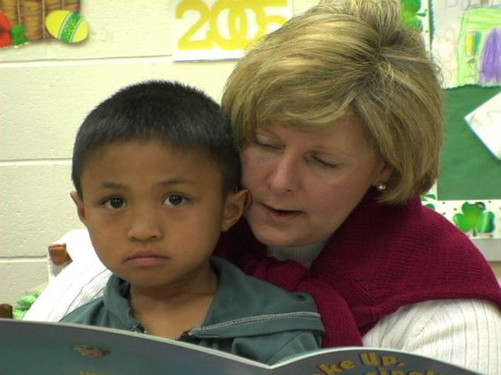 Boy from Burma with his teacher at school