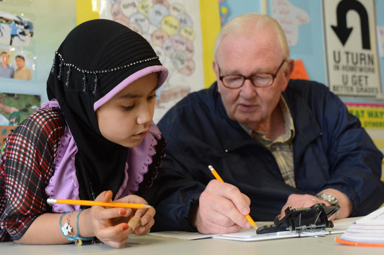 Burmese Muslim girl receiving assistance with her homework