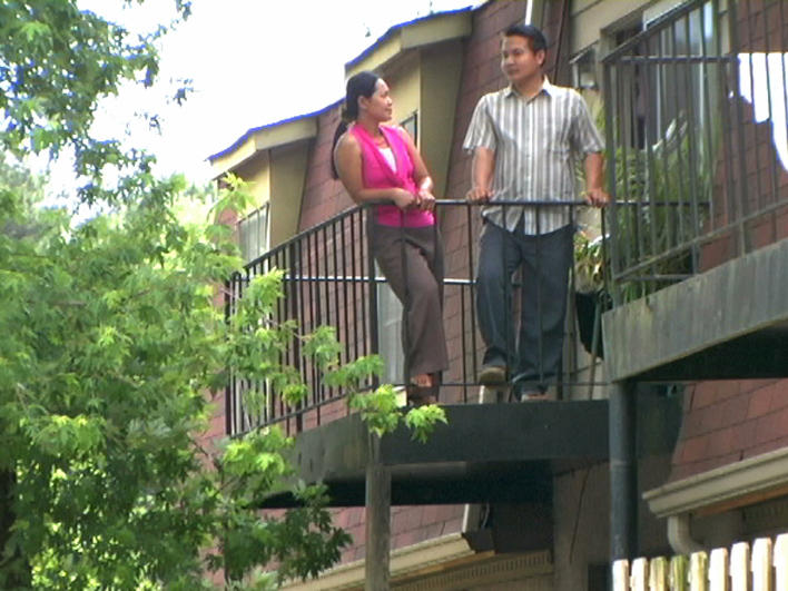Couple talking on their balcony