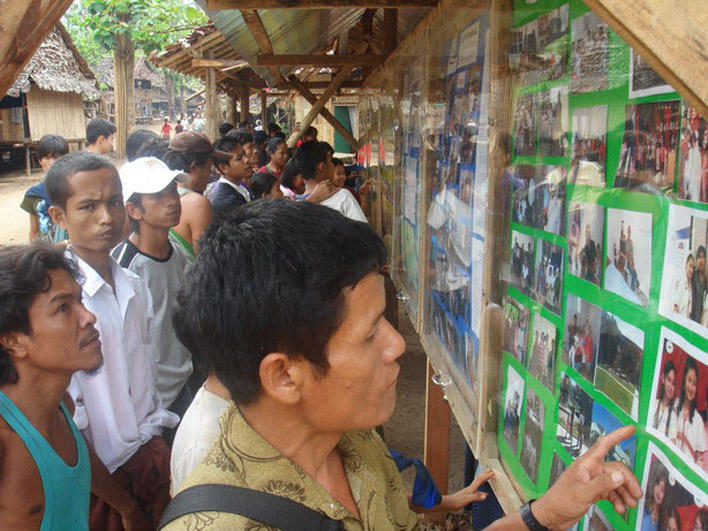 Refugees looking at the resettlement picture board