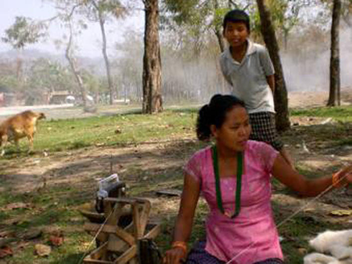 Woman spinning near refugee camp